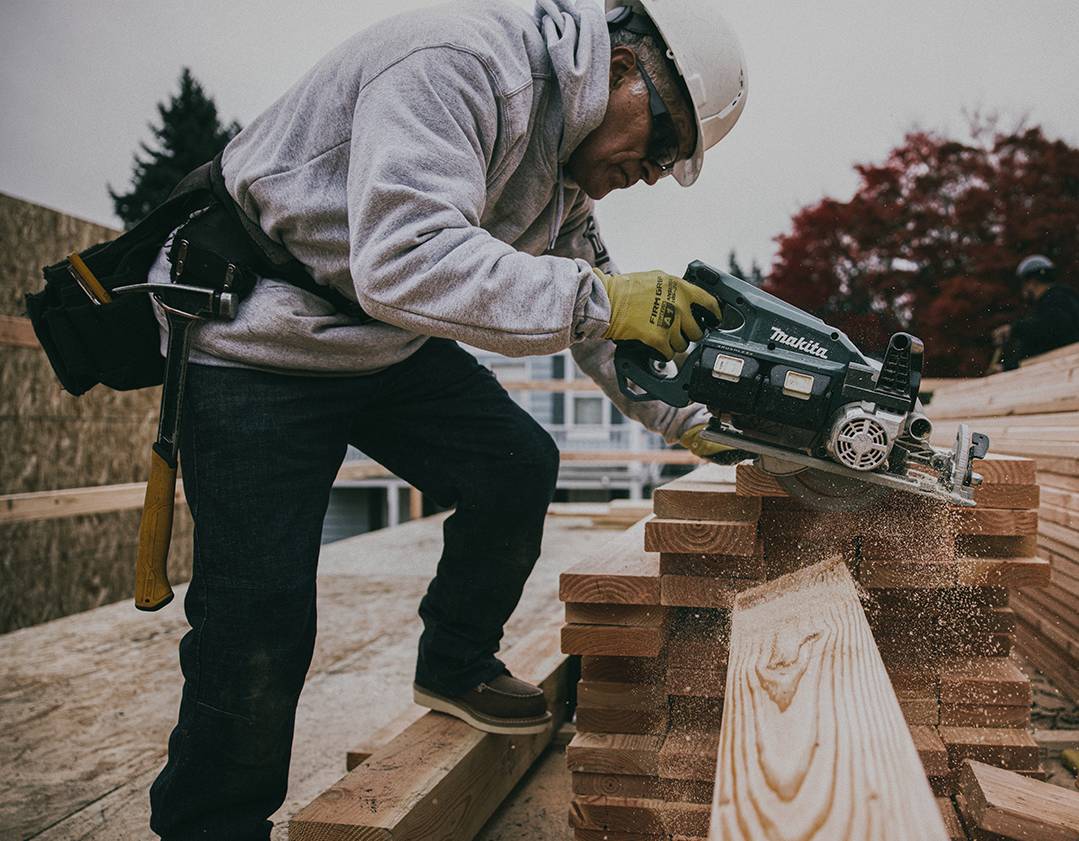 Worker sawing wood